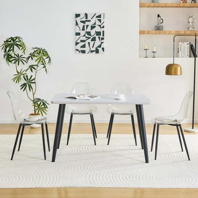 Modern Rectangular Dining Table and Transparent Plastic Chair Set with Metal Legs, Combining Sleek Aesthetics, Structural Stability, and Space-Enhancing Transparency.