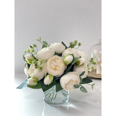 Arrangement de pivoines roses dans un vase en verre classique