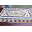Tapis kilim turc fait à la main avec des motifs géométriques vibrants dans un design pastel coloré offrant un ajout unique à votre décor