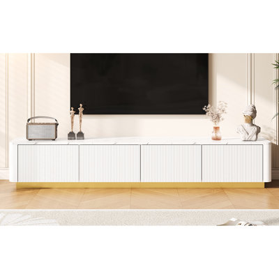 Meuble télé de luxe avec 4 tiroirs, base dorée, finition en faux marbre blanc et esthétique cannelée incurvée