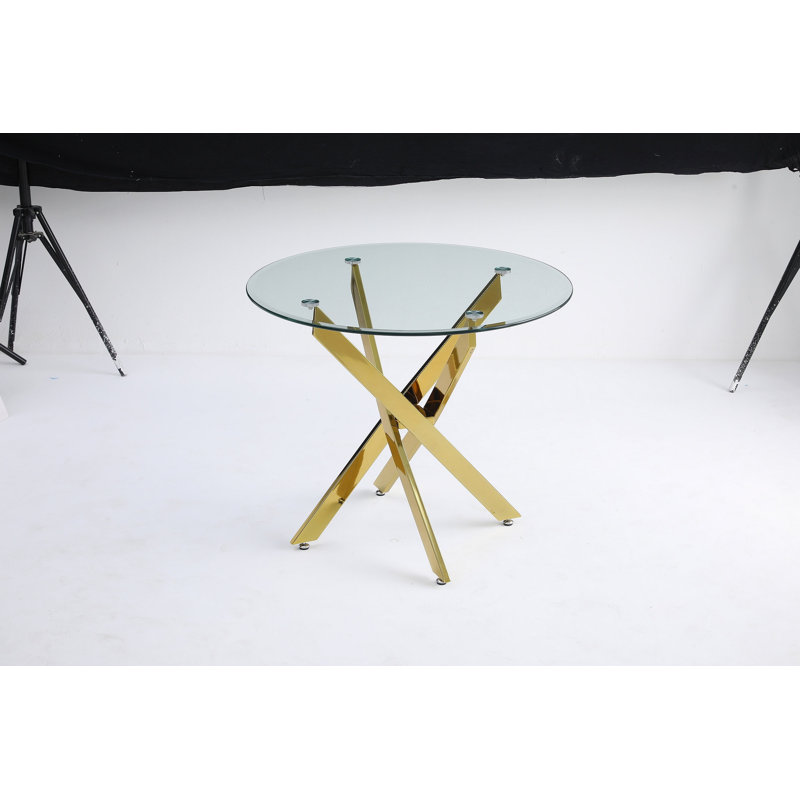 Le plateau de table circulaire en verre trempé moderne est jumelé à un cadre en fer doré mesurant 35,43 pouces de longueur.