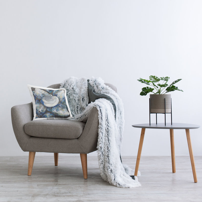 Coussin bleu à motif de coquillages imprimés par Jeanette Vertentes