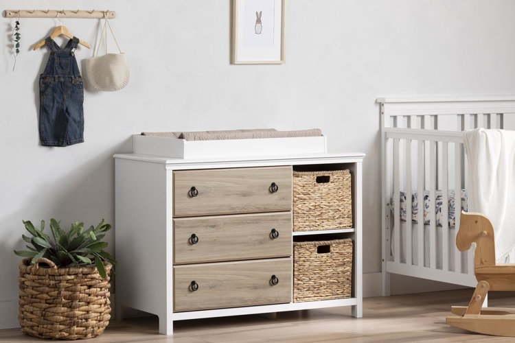 beige nursery with a wooden changing table dresser with woven storage bins