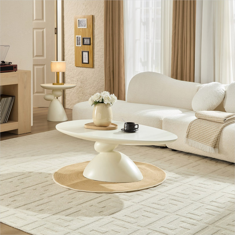 Table basse ovale en fibre de verre aux tons blancs avec base sculpturale en pierre porte-bonheur pour un salon de style minimaliste moderne