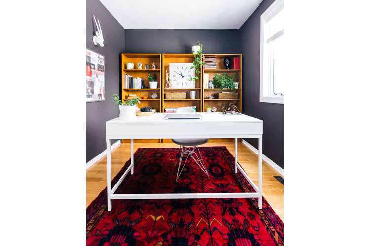 An office with navy walls and a white desk