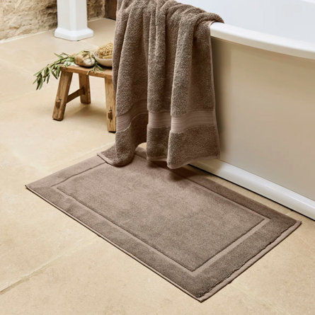 Brown bath mat and towel in bathroom.