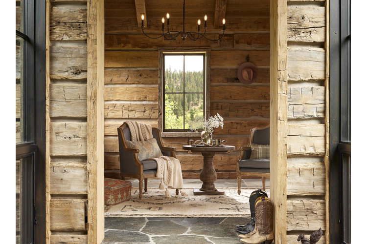 The doorway of a western ranch-style home with cowboy boots by the door and a seating area just inside.