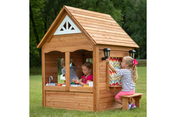 kids playing in a built wooden playhouse