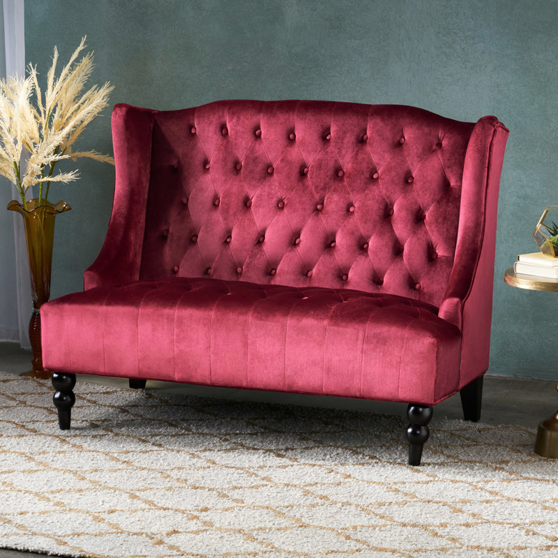 Élégant fauteuil à oreilles en velours avec coussins à boutons - Rouge vineux avec détails touffetés