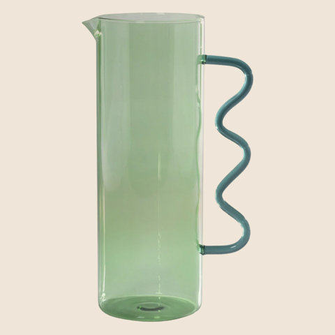 Tall translucent light green glass pitcher with a decorative wavy teal handle.