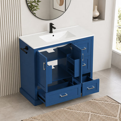 Meuble-lavabo sur pied de 108 cm (42,42 po) bleu marine avec lavabo en céramique, 4 tiroirs, portes à fermeture amortie, porte-serviettes réversible et structure en MDF.
