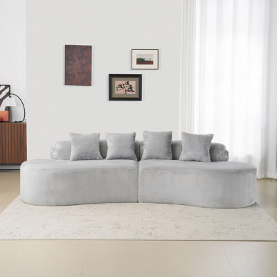 Simple Curved Flannelette Sofa. Creative Multi-Seater In Light Gray For The Living Room, With A Combination Of Pillows