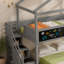 Un lit superposé multifonctionnel gris minimaliste avec rangement à plusieurs niveaux dans l'escalier et un panneau de tableau créatif sur le côté - combinant sans effort un espace de jeu avec un rangement pratique.