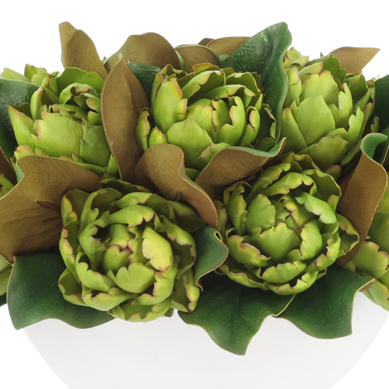 Arrangements floraux de magnolia et d'artichaut dans un pot en fibre de pierre