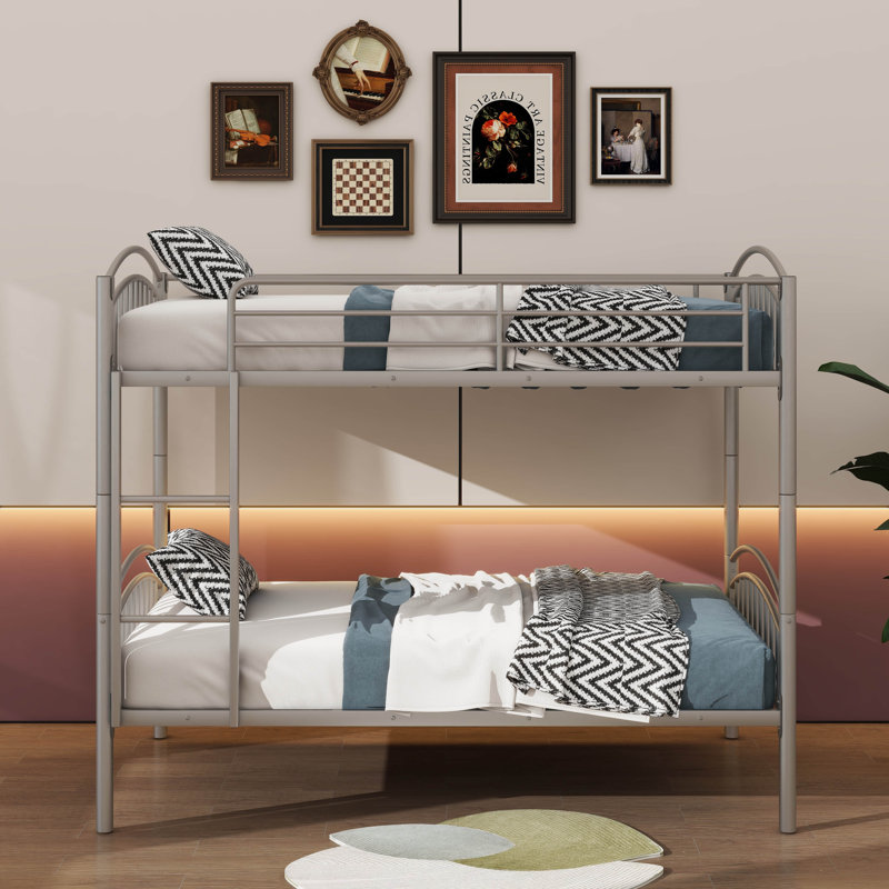 Le lit superposé simple au-dessus d'un lit simple en métal et l'échelle amovible peuvent être séparés en deux lits