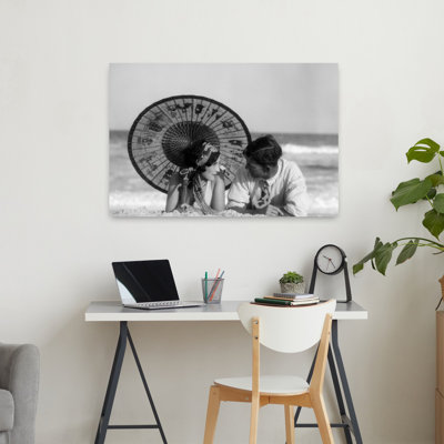 1920S Romantic Couple Man Woman Looking At One Another Lying Face To Face Under Oriental Parasol On Sandy Beach Classic Retro Romantic Beach Portra...