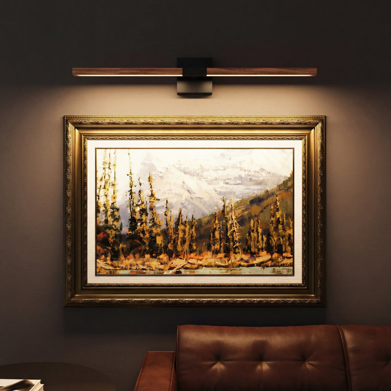 Cordless picture light with a walnut and matte black finish mounted above a framed landscape painting on a dark wall.