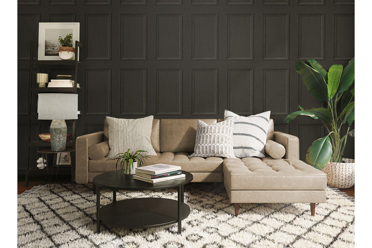 Living room with black walls, a beige sectional, and a white patterned rug.