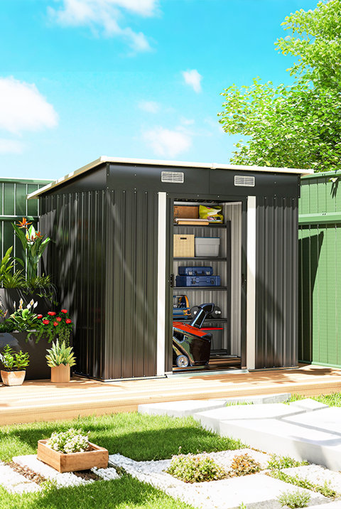 Black metal garden storage shed with open double doors showing interior shelving stocked with tools and equipment, positioned on a wooden deck in a sunlit garden.