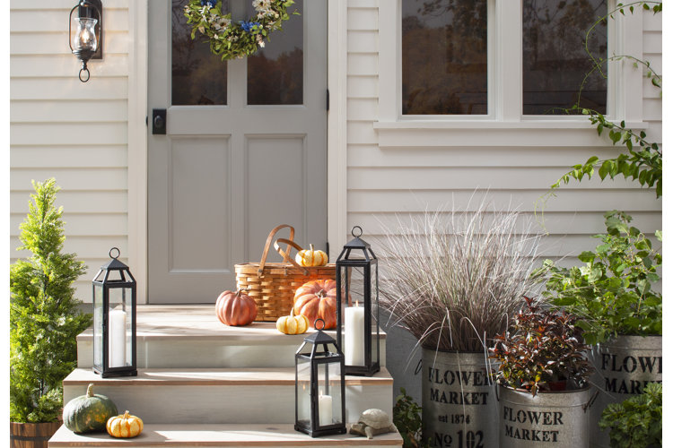 fall front porch with plant stands and pumpkins
