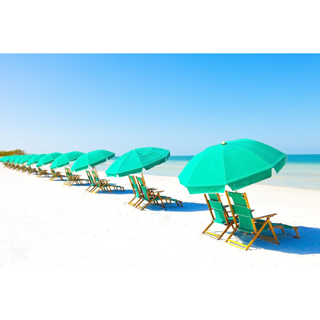 Liegestühle und Sonnenschirm am Strand von Bertlmann - Leinwandbild