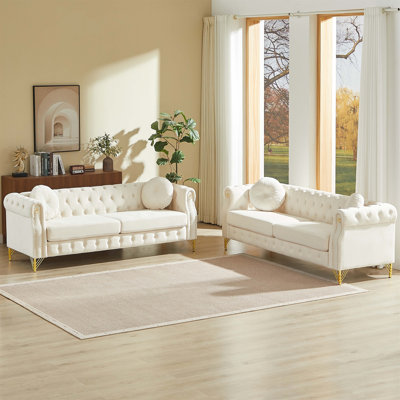Canapé Chesterfield en velours avec coussins ronds, boutons touffetés, clous en cuivre, anneaux d'accoudoirs décoratifs et pieds en métal