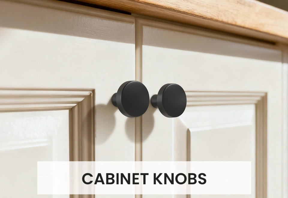 Two matte black round cabinet knobs installed on off-white kitchen cabinet doors with the text Cabinet Knobs centered at the bottom.