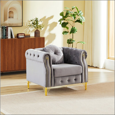 Luxueux canapé Chesterfield en velours avec coussins ronds, clous en cuivre, boutons touffetés et pieds en métal pour des espaces de vie élégants