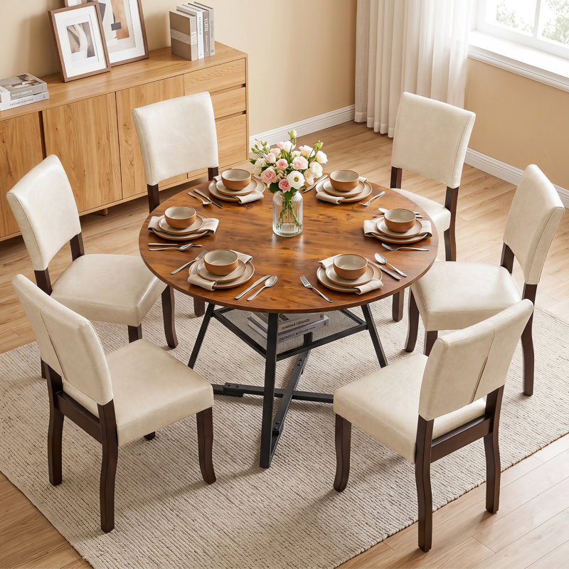 Ensemble table et chaises de salle à manger : table ronde industrielle de 107 cm (42 po) avec piètement croisé et étagère de rangement en maille, et chaises de salle à manger en bois rembourrées de style milieu du siècle.