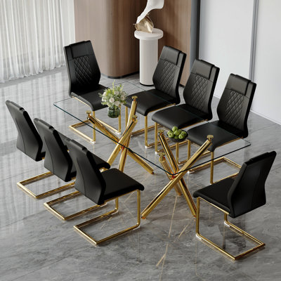 Ensemble de table et de chaises. Ensemble de table de salle à manger moderne et luxueux en verre trempé transparent avec 8 chaises. Pieds de table en métal doré à double fourche.