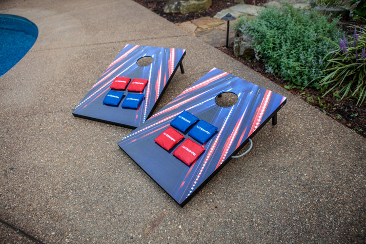 two red, white, and blue corn hole boards on pavement