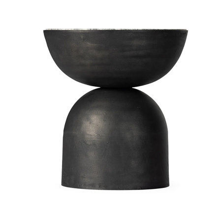 A black accent table made from a half-sphere balanced atop a dome.
