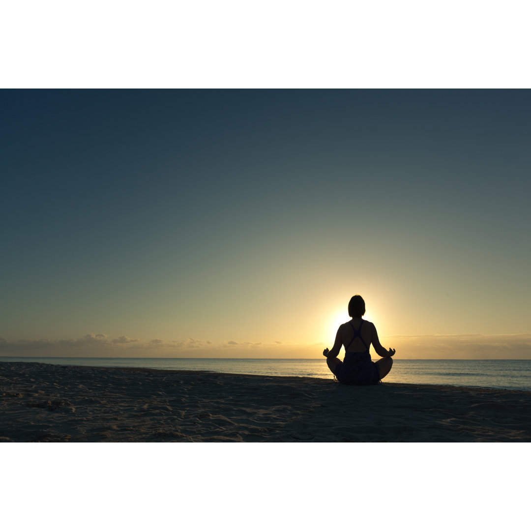 Yoga Lotus Pose bei Sonnenaufgang in der Karibik Strandurlaub