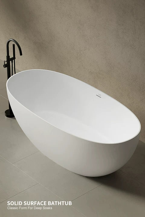 White oval freestanding bathtub with matte black floor-mounted faucet in a minimalist bathroom with the text SOLID SURFACE BATHTUB Classic Form For Deep Soaks.