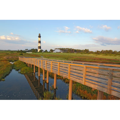 Walkway Over A Marsh To The Bodie Island Lighthouse by Sgoodwin4813 - Wrapped Canvas Print