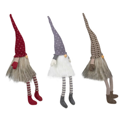 Gnomes de Noël assis avec des pieds suspendus