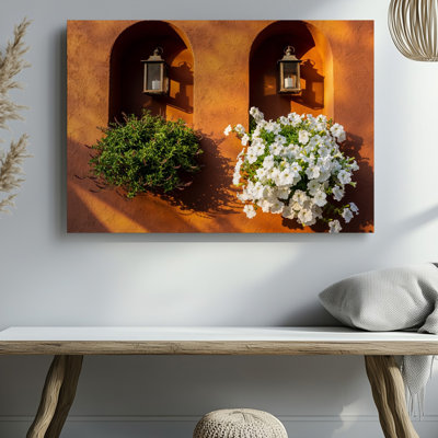 Toile Un mur texturé orange vif sert de toile de fond avec art mural Deux niches arquées et une niche présentant un art mural rétro