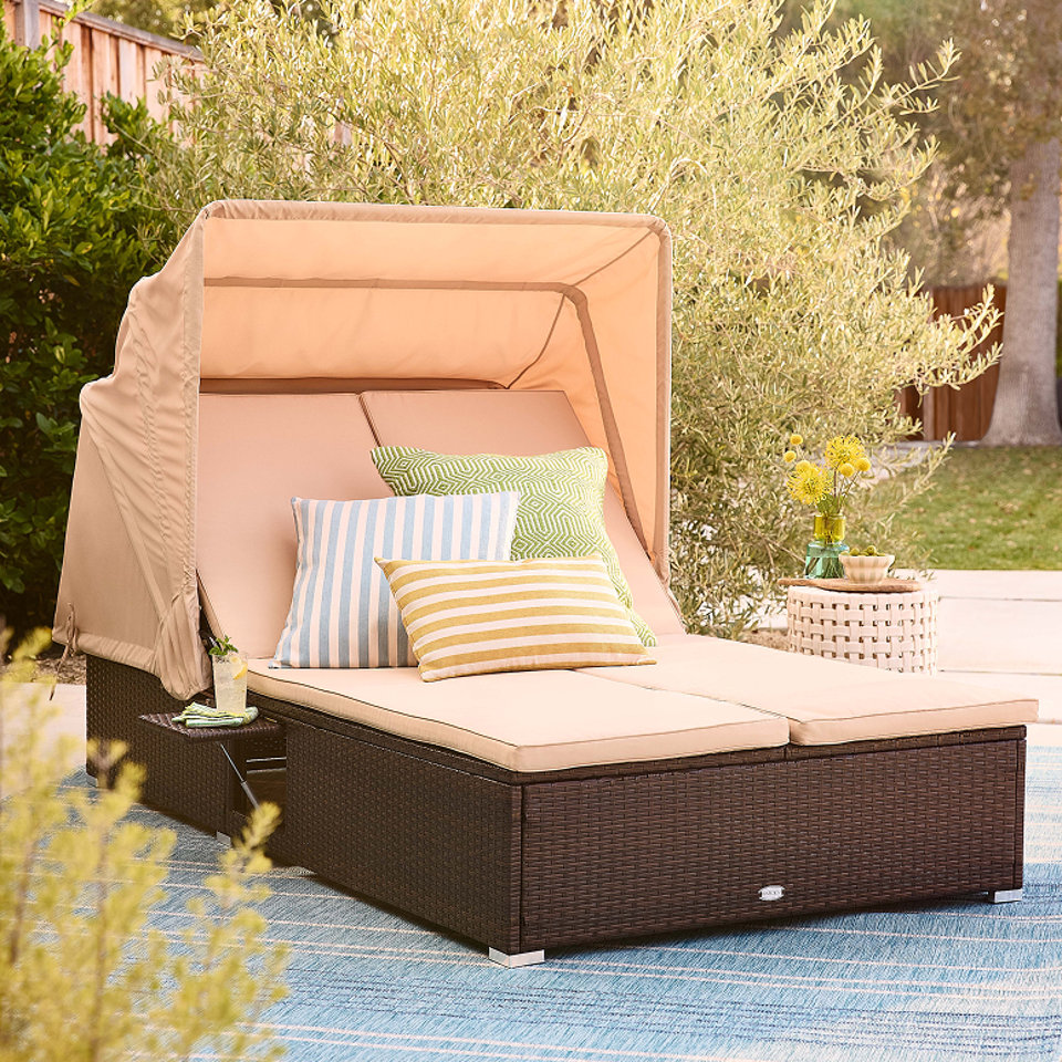 Outdoor daybed with canopy and accent pillows.