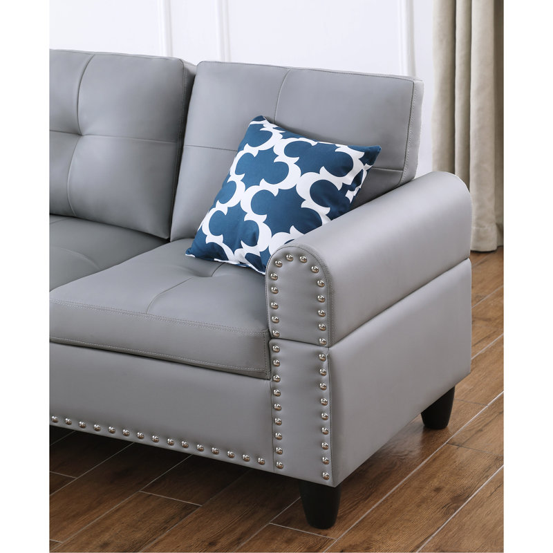 Canapé d'angle en L 3 pièces en similicuir gris, idéal pour des séances de cinéma et des jeux vidéo relaxantes. Siège central rabattable avec porte-gobelets, deux coussins décoratifs et rangement. Structure en bois massif et composite, profil bas.
