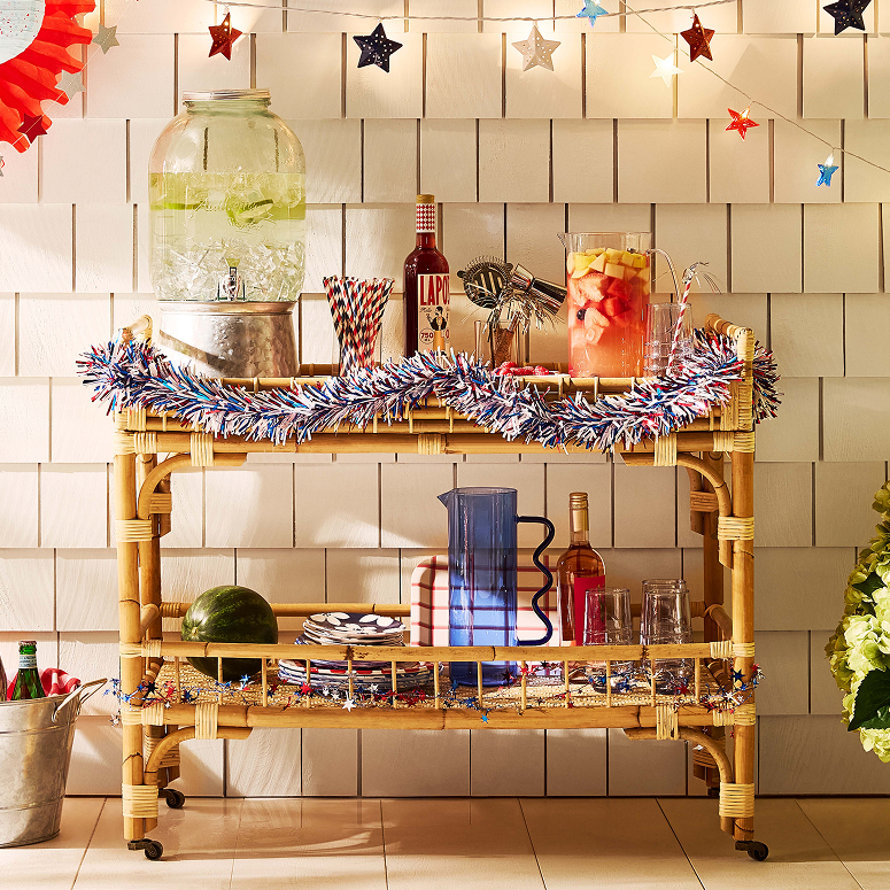 Bamboo bar cart decorated with patriotic garland and party supplies