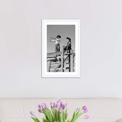 «1950s Two Young Boy Dressed as Cowboys Shoot Slingshots on Top of Wooden Fence Outdoor», reproduction de photo sur toile tendue