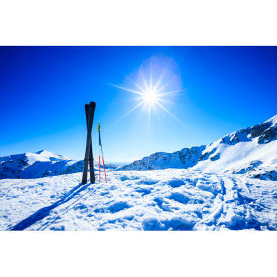 Skis sur le dessus de la pente contre le soleil par mbbirdy