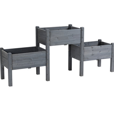 Jardinière surélevée grise avec 3 jardinières pour la culture d'herbes aromatiques. Aménagement surélevé en bois. Abondance d'herbes aromatiques, de légumes et de fleurs.