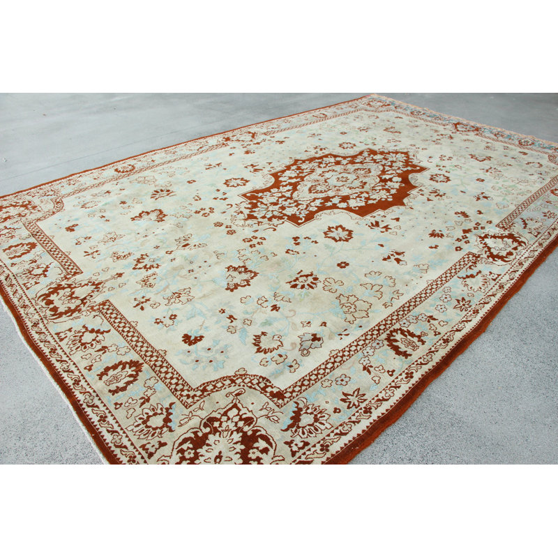 Tapis turc rétro à motif floral beige parfait pour votre salon spacieux