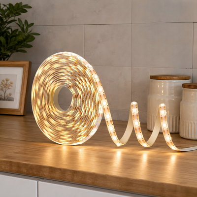 This battery-powered 9.8FT warm-white strip uses 90 LEDs and includes remote operation, 8 modes, dimming, a timer, self-adhesive backing, cuttable construction, and waterproofing for TV, kitchen, cupboard, or bedroom decor.