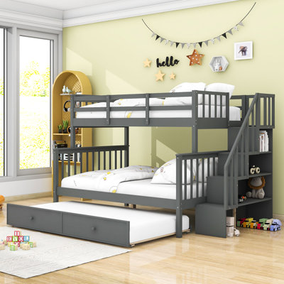 Lit superposé simple au-dessus d'un lit double en bois avec lit gigogne simple