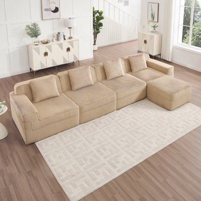 Canapé modulaire moderne en L à 4 places avec sièges profonds, coussins décoratifs et repose-pieds mobile pour un confort et une polyvalence ultimes