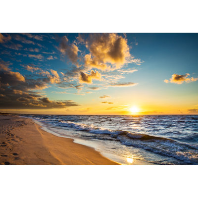 Sunset Over The Beach And Ocean by Konradlew - Wrapped Canvas Print