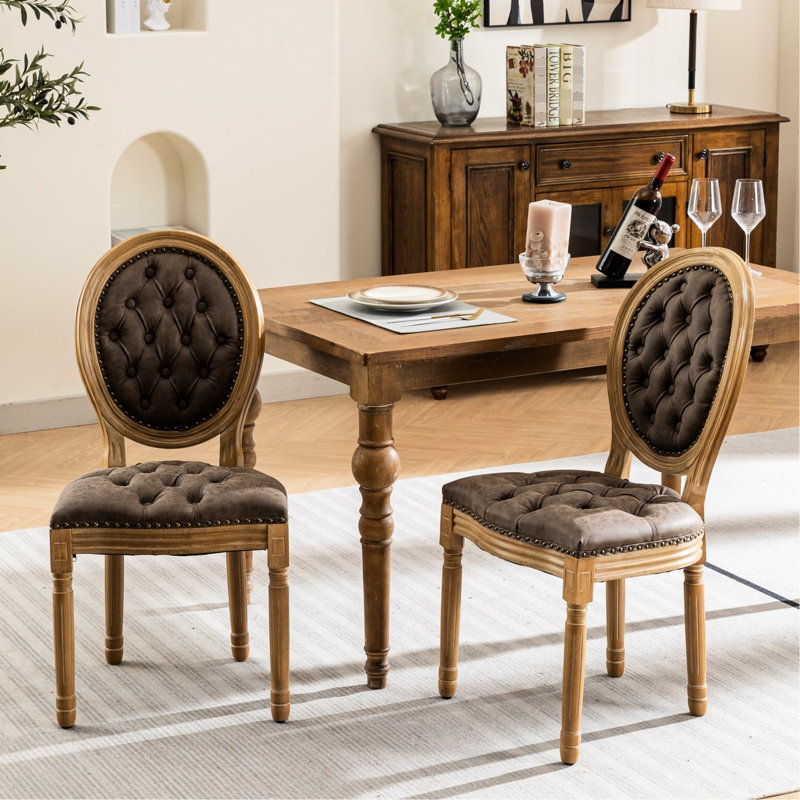 Deux chaises de salle à manger en cuir brun, une base en bois massif, une boucle ornée à la main, des sièges et des pieds en cuir, une structure et un coussin à ressorts en éponge