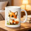 A Charming Ceramic Coffee Mug Featuring a Playful Orange Fox Surrounded by Green Leaves And Dandelions, Perfect for Halloween.